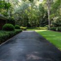 a well-maintained driveway leading to a lush green yard.